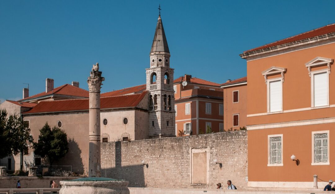 Zadar, Croatia bell tower and church against blue sky, with old stone fortifications and rooftops