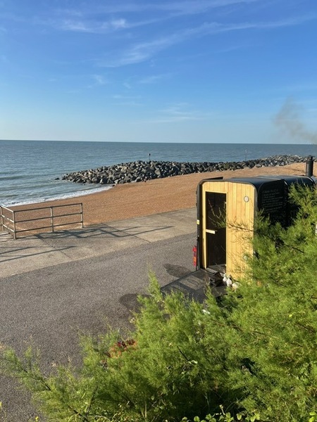 Seaside sauna cabin by rocky seawall with steam rising over the ocean