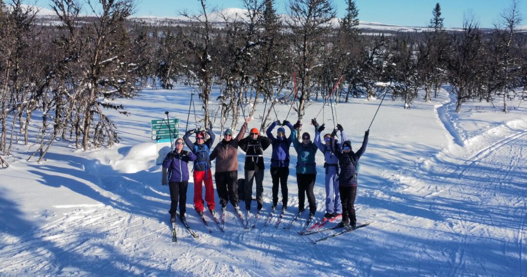 Group of women cross-country skiing in snowy countryside on a winter trail near trees