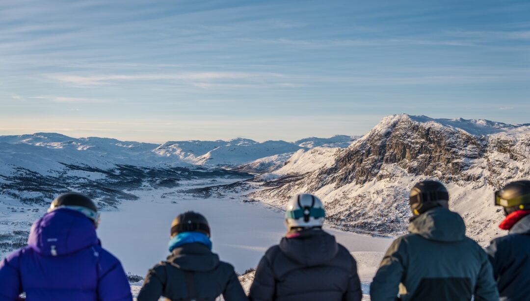 Skiers look over snow-covered mountains in Norway during a downhill ski holiday
