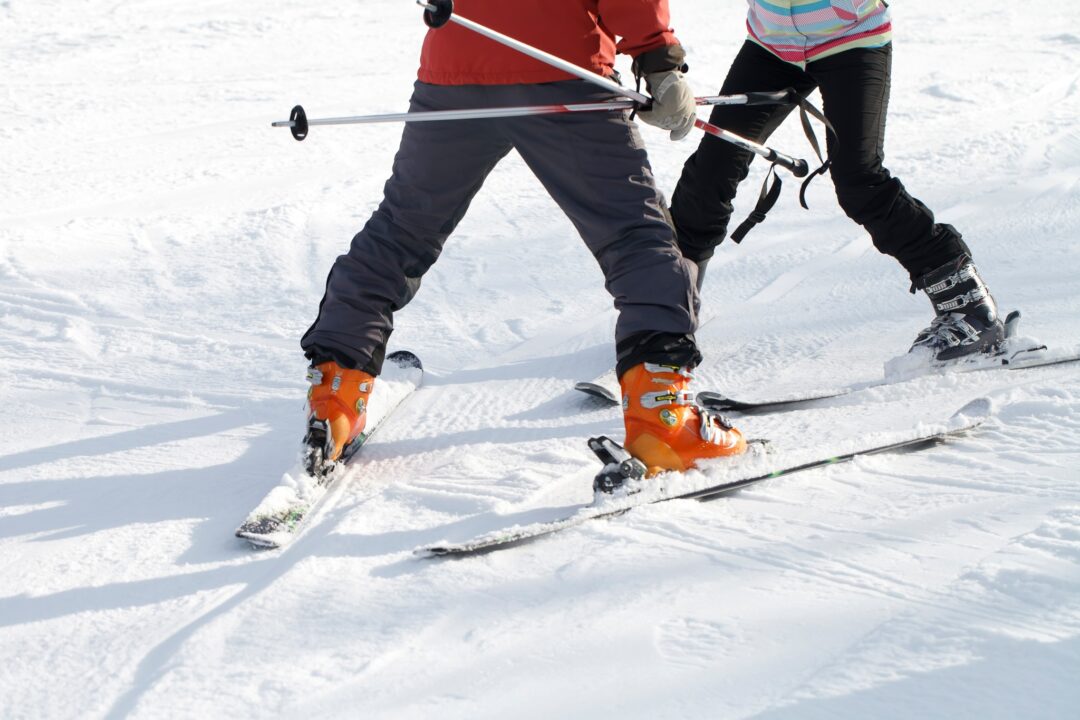 Women downhill skiing on snow, carving turns in ski boots and skis