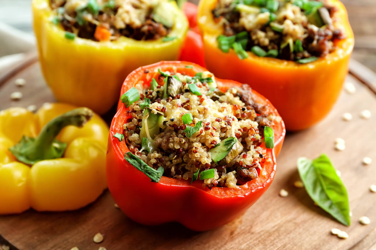 Stuffed bell peppers with quinoa and herbs on a wooden board