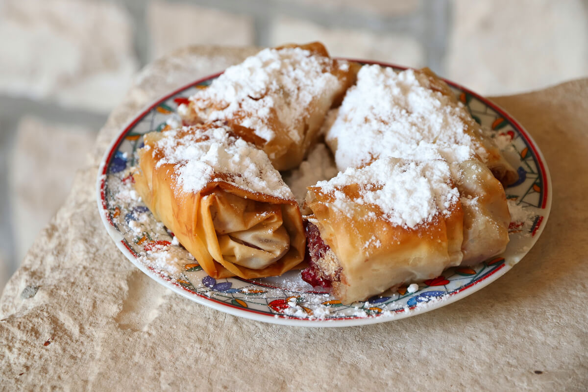 Powdered sugar pastries on a plate on a stone surface