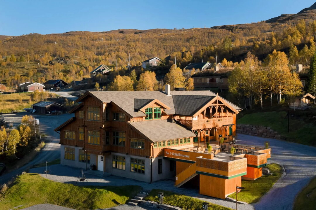 Norway mountain lodge and cabins in a valley with autumn trees and surrounding peaks