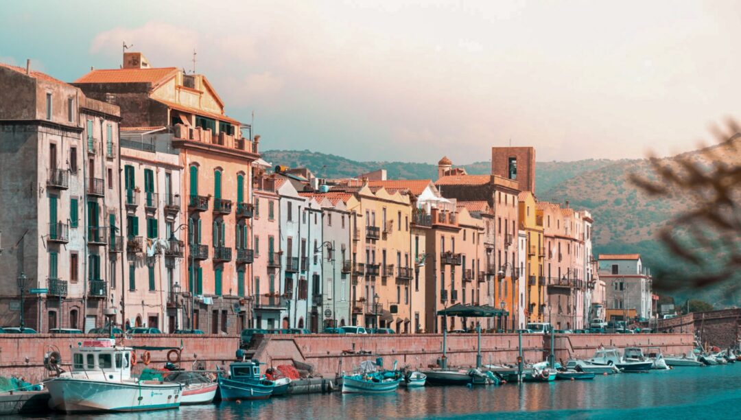 Coastal harbour with moored boats and pastel buildings along the waterfront in a European town