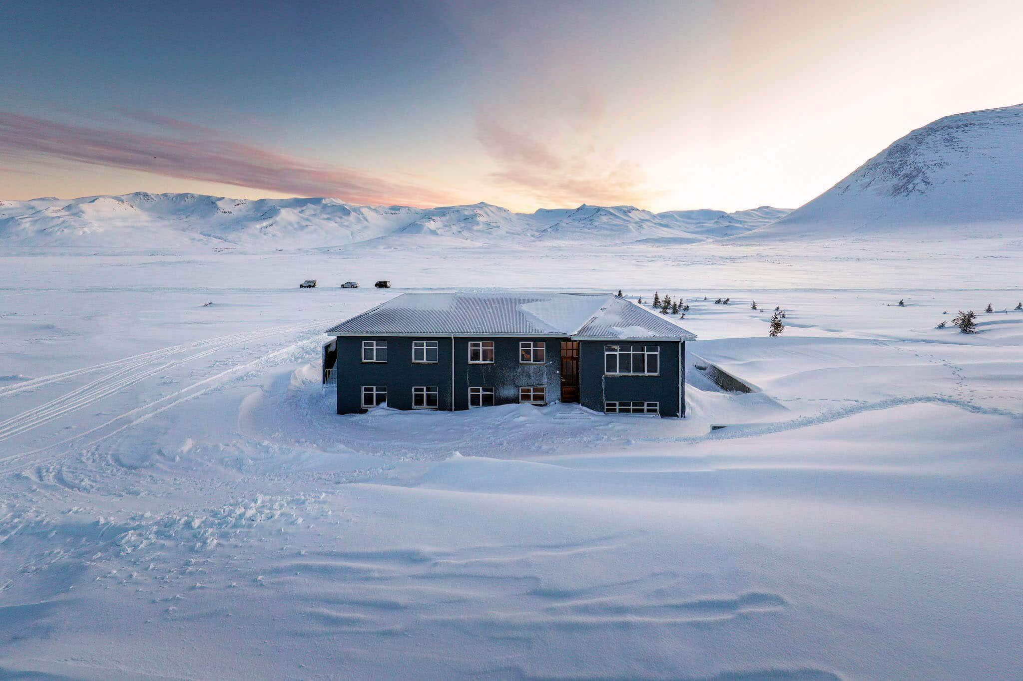 Snow-covered landscape with a lodge in North Iceland at winter sunrise