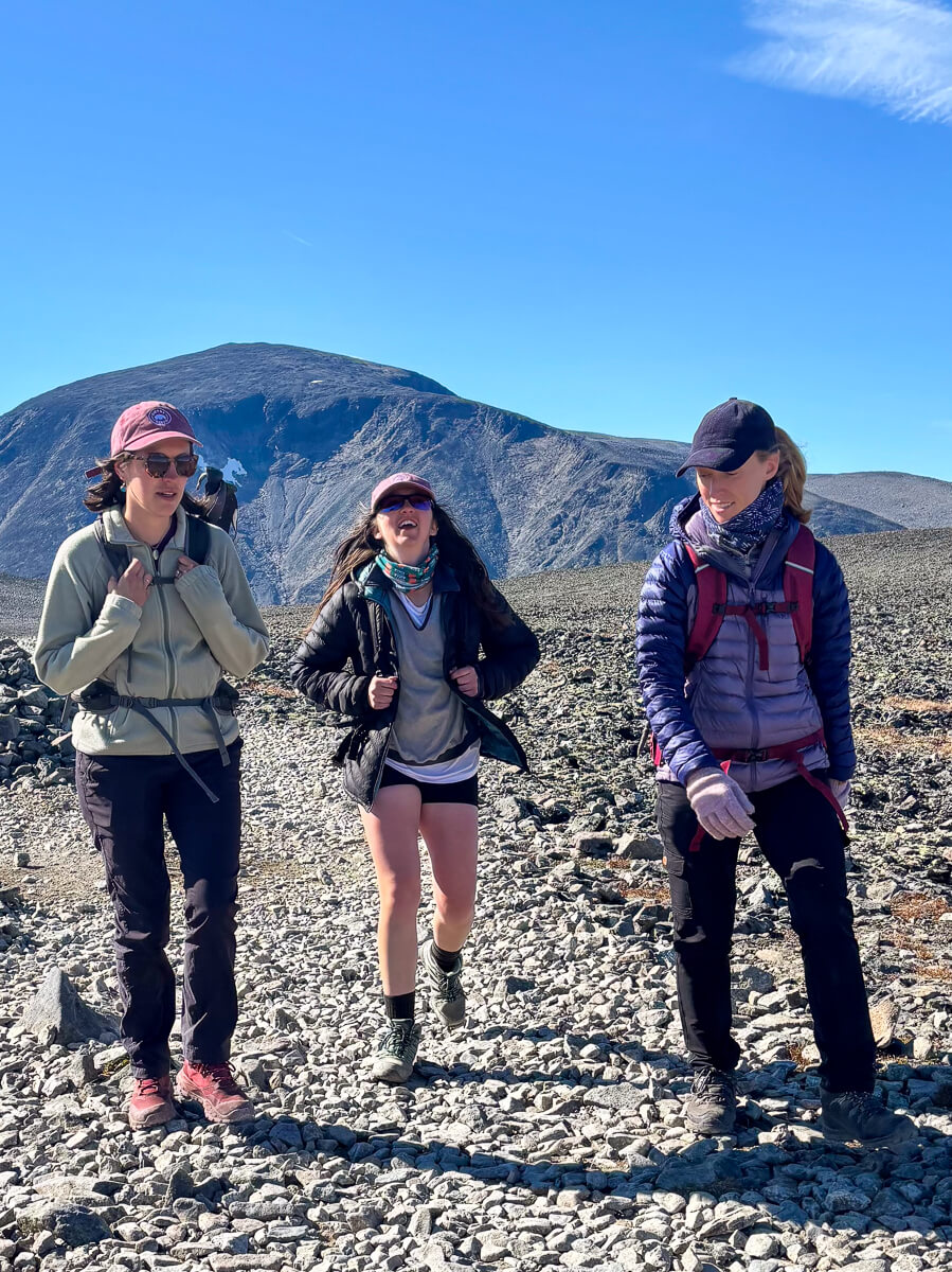 Women hiking on a rocky mountain path in Norway during a hiking and yoga holiday