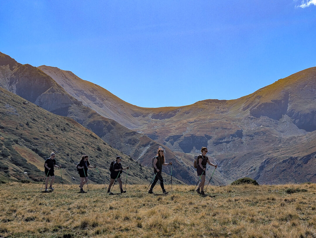 Women hiking across a mountain valley on a guided trekking holiday