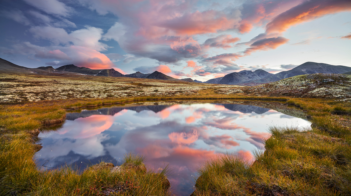 Mountain landscape with a still pond at sunset, suitable for beginner hiking and yoga