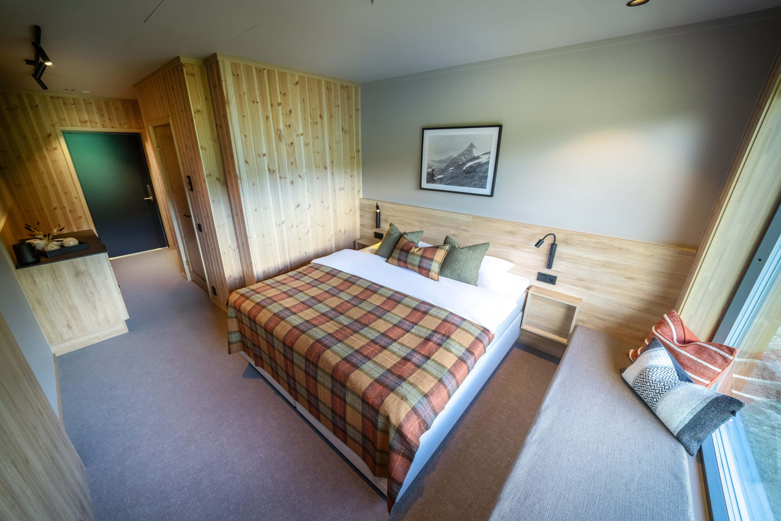 Modern wooden bedroom with double bed, bedside tables and wall-mounted lamp