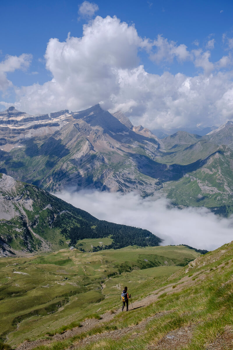 Hiker on a mountain trail with cloud-filled valleys in the Spanish Pyrenees