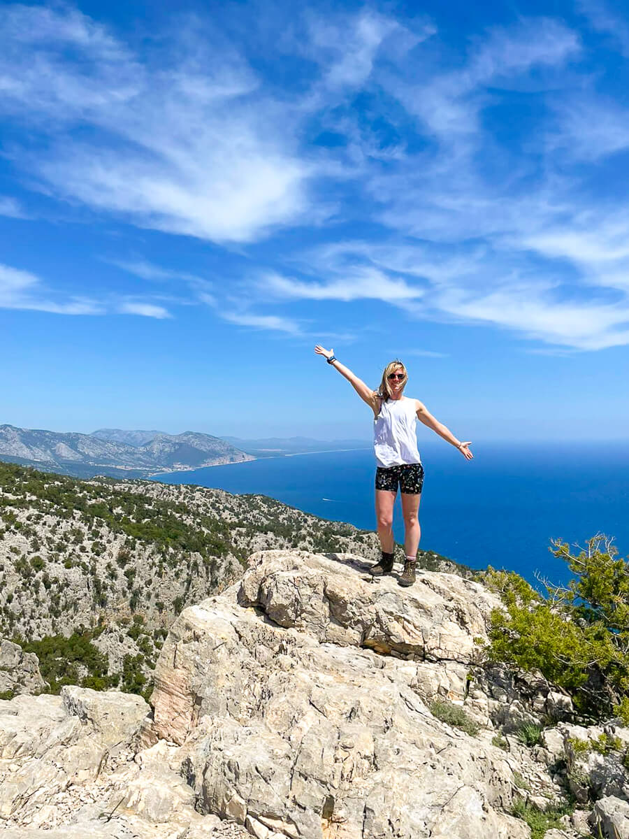 Woman hiking on a rocky cliff overlooking the sea on Sardinia’s east coast