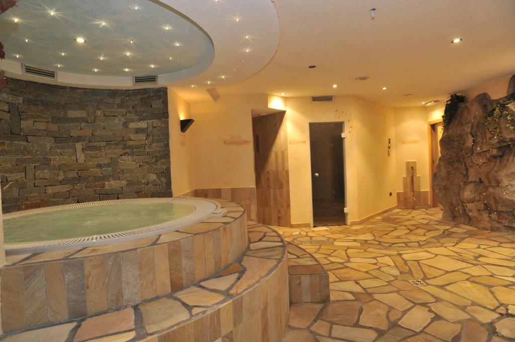 Indoor spa pool with hot tub in a stone-walled relaxation area