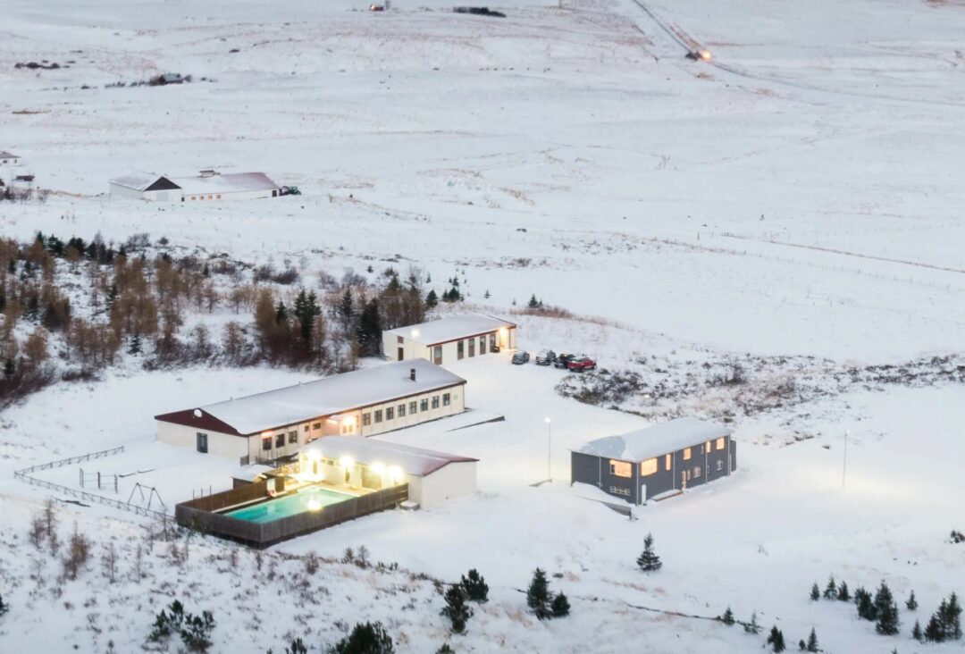 Snow-covered lodge complex in North Iceland, aerial winter view of buildings and surrounding landscape