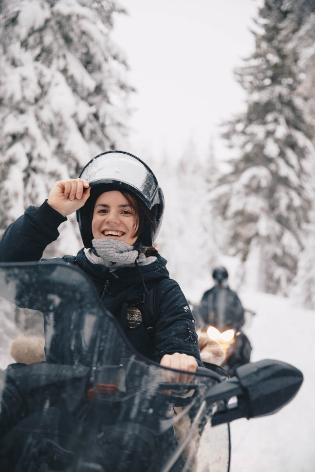 Woman snowboarding in a snowy pine forest on a winter adventure holiday