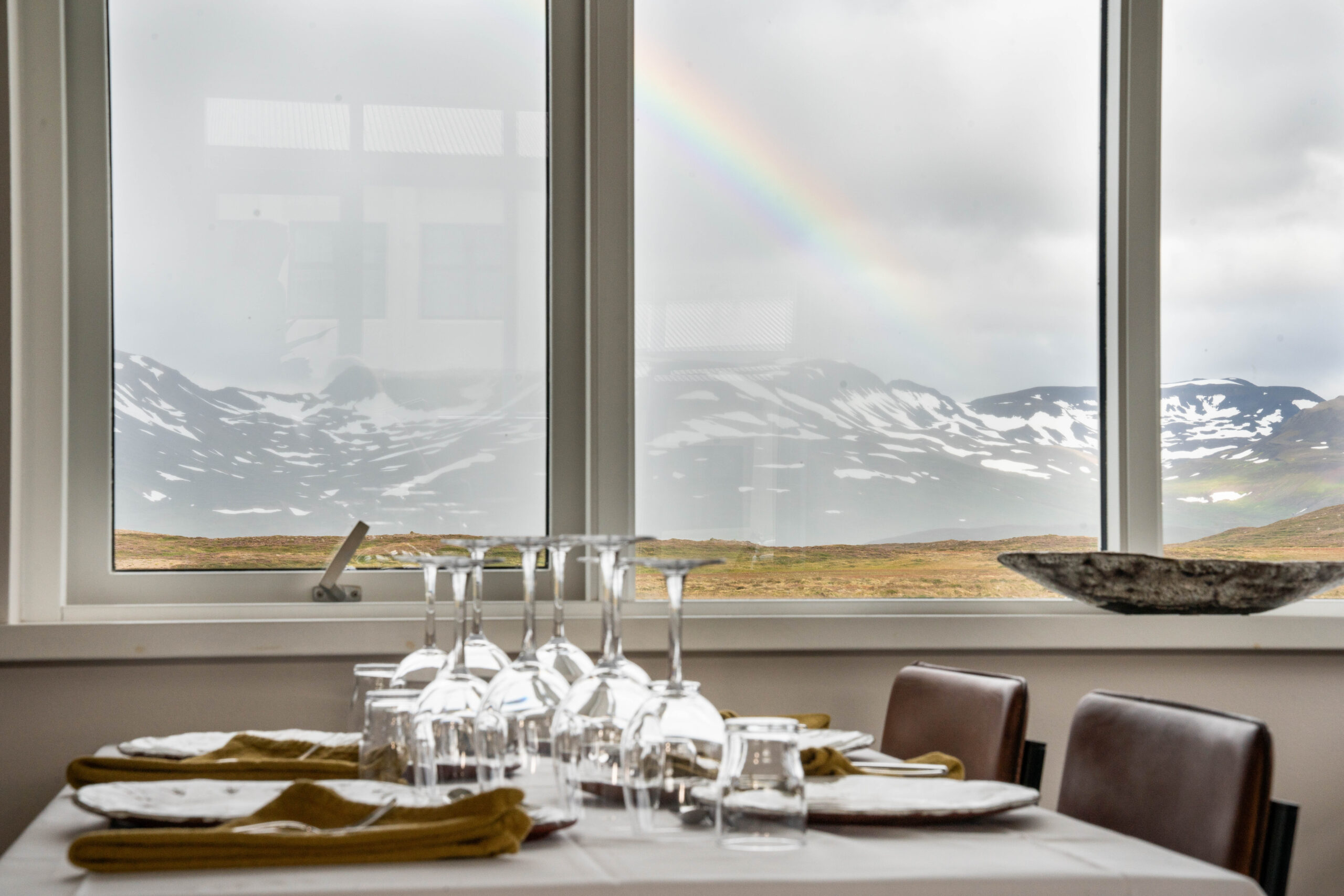 Dining table by a window with a view of snowy mountains in Iceland