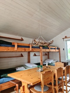 Wooden cabin interior with sleeping bunks and reindeer antler decor