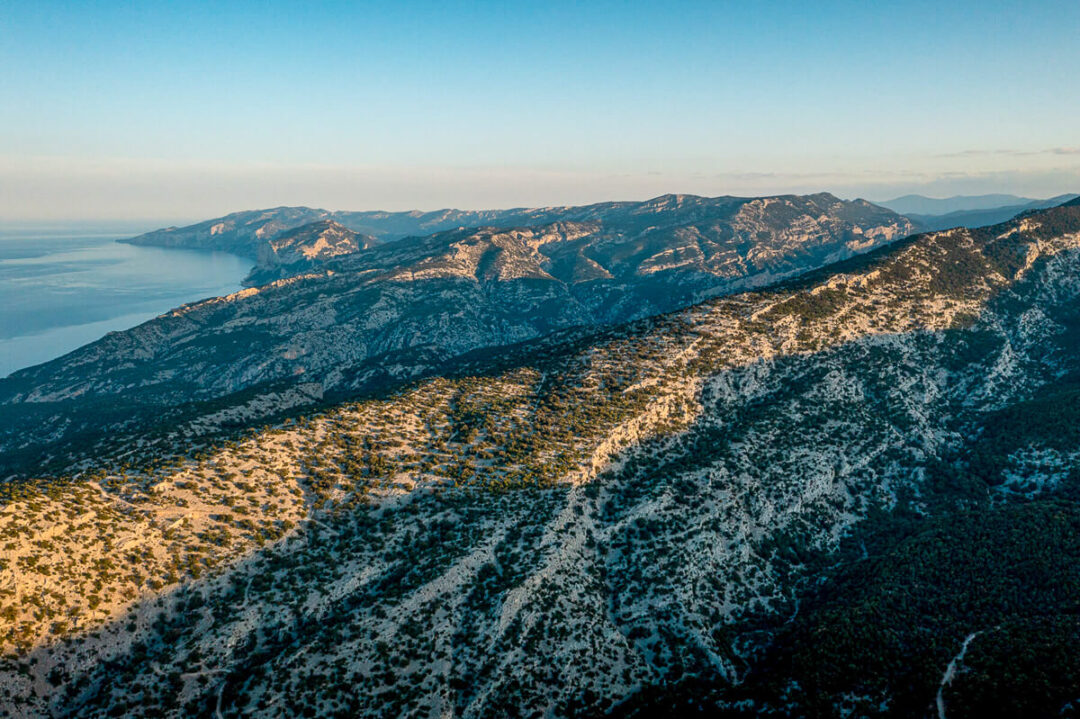 Rugged ridgeline and coastline on Sardinia’s east coast, aerial view of a hiking landscape
