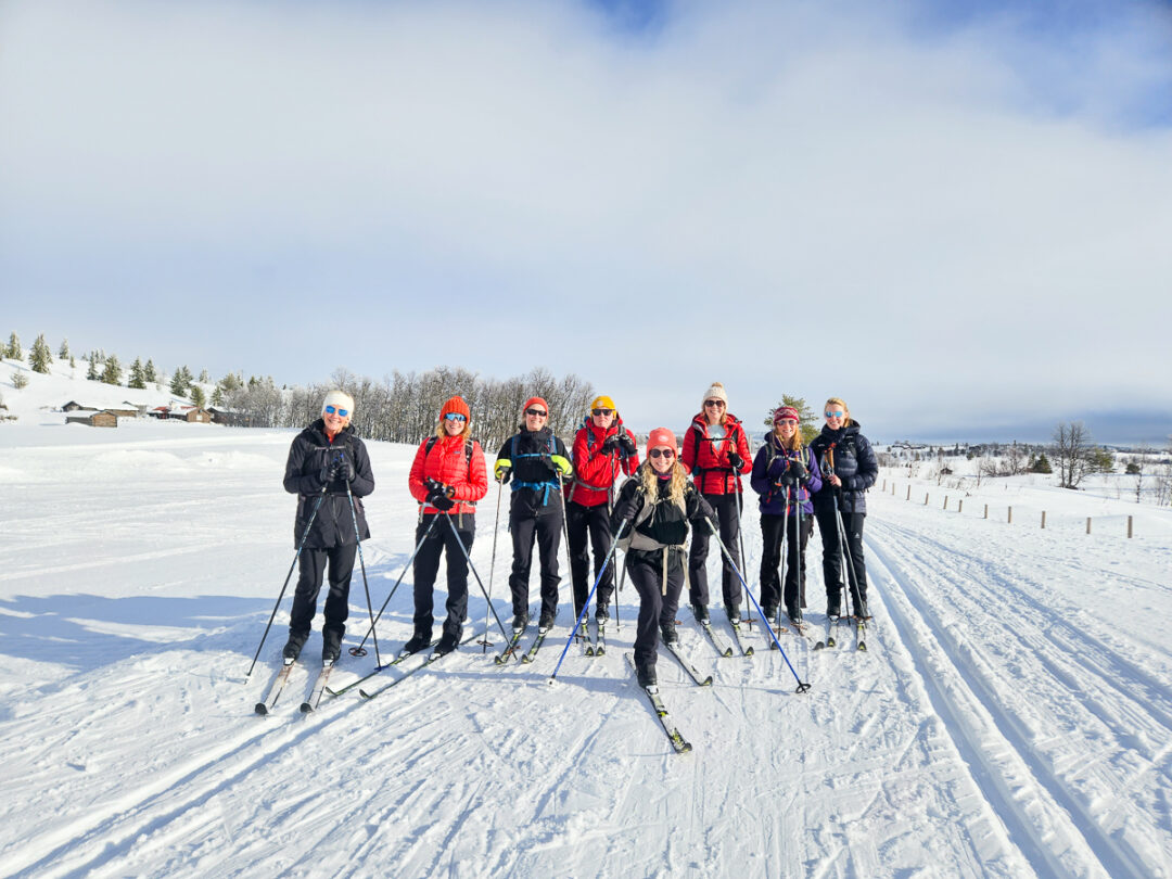 Women cross-country skiing as a group on snowy tracks in a winter landscape