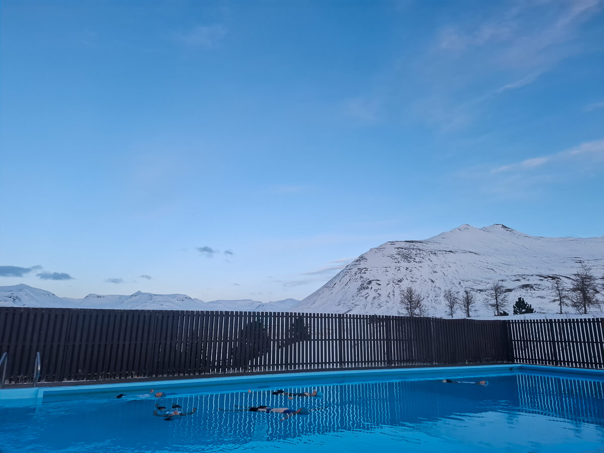 Outdoor swimming pool with snowy mountains in northern Iceland during winter