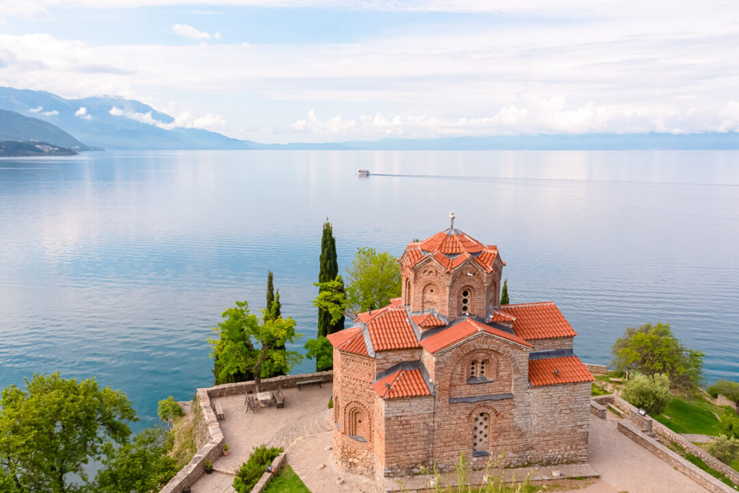 Church with red-roof bell tower overlooking Lake Ohrid, North Macedonia