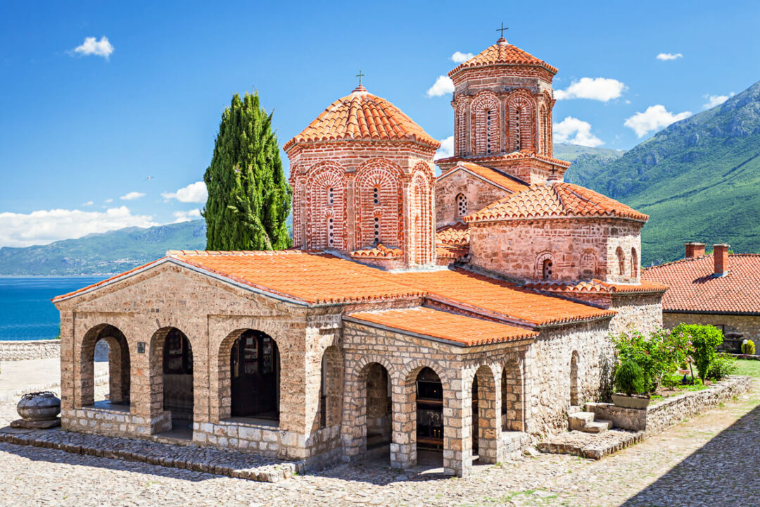 Historic church by Lake Ohrid in North Macedonia, with red-domed roof and seaside views