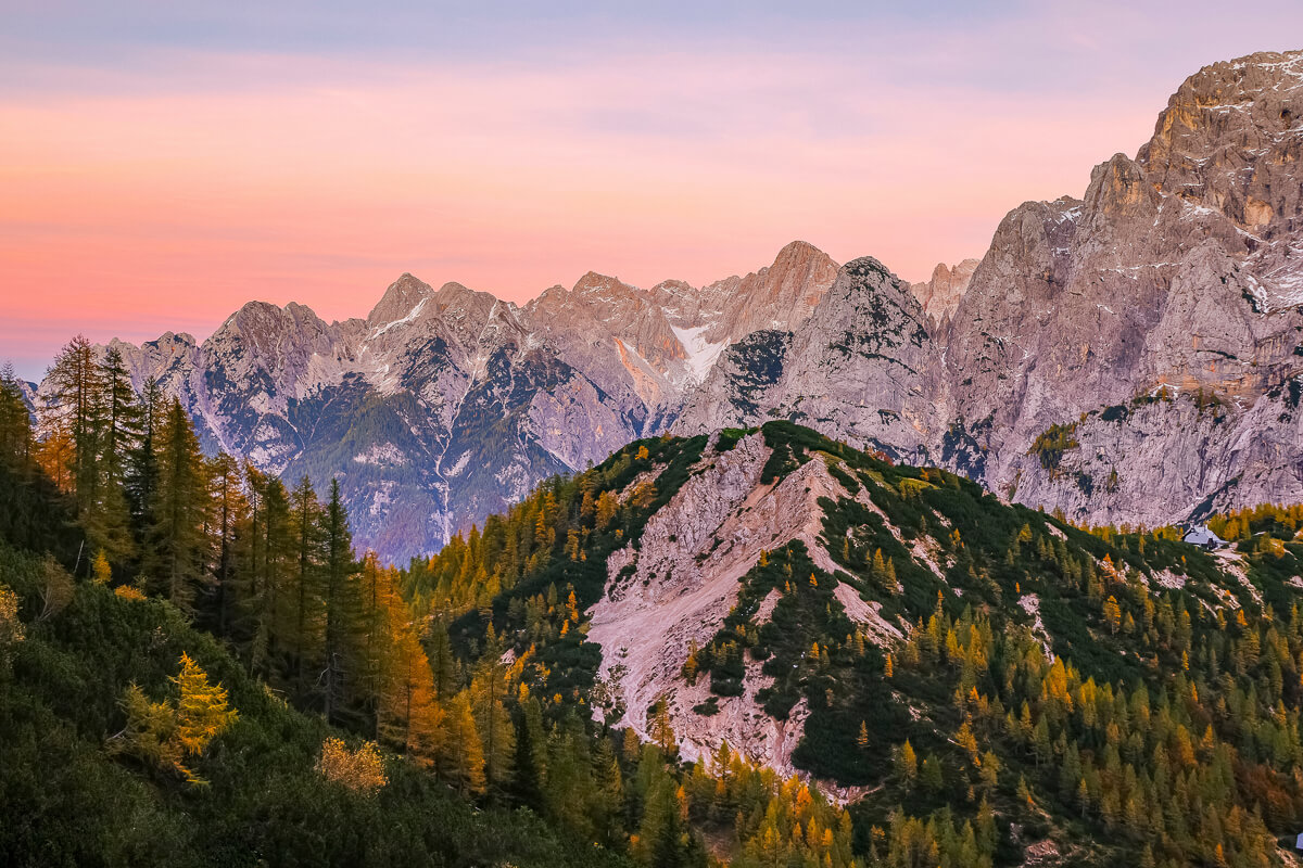 Scenic mountain landscape at sunset with forested slopes and rocky peaks across Europe