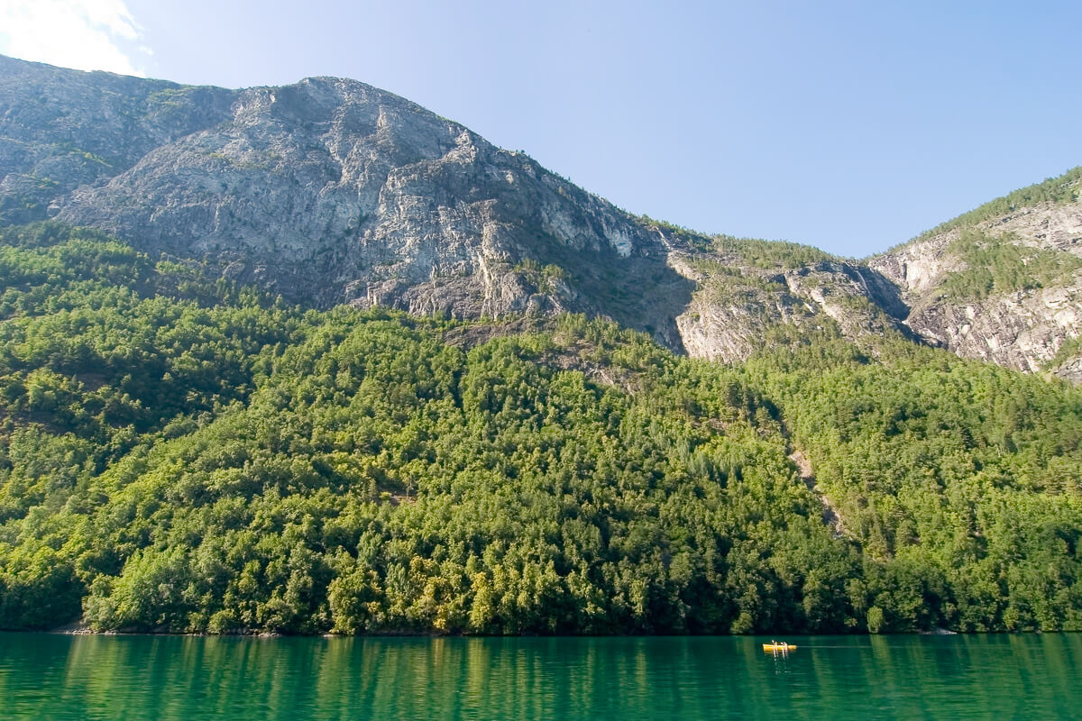 Mountain landscape with a calm lake and forested slopes in Jotunheimen National Park, Norway