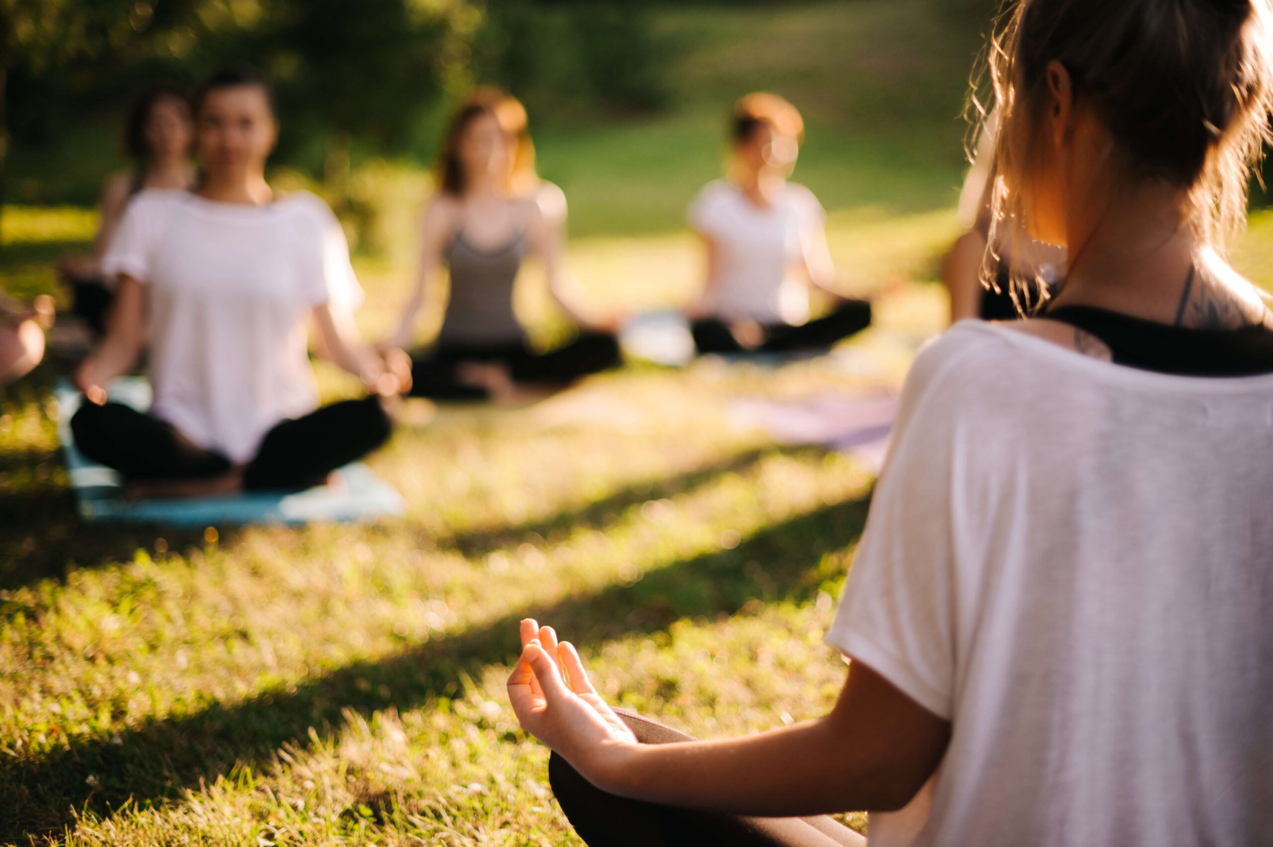Women practising yoga on outdoor grass during a multi-activity holiday in north Macedonia