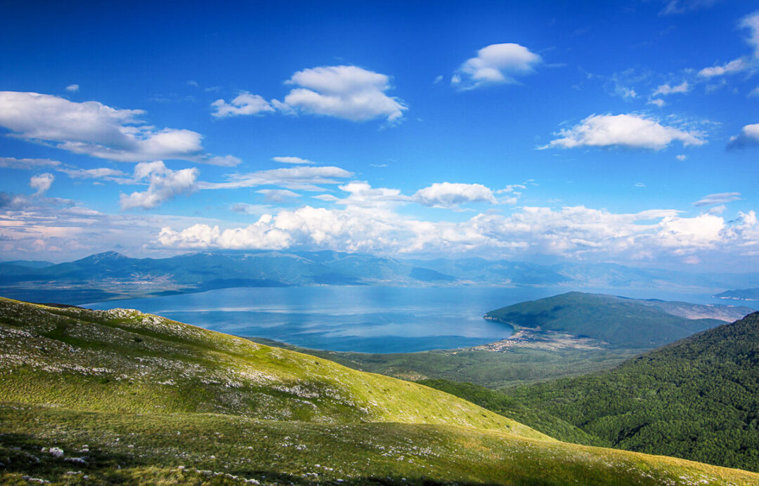 Panoramic view over Lake Ohrid and mountains from a grassy hillside in North Macedonia