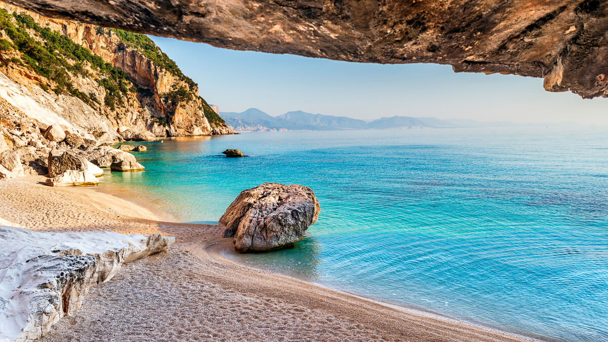 Rocky beach on Sardinia’s east coast with turquoise sea and coastal cliffs