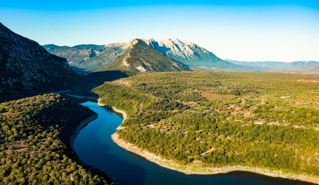 River winding through green valley with mountains in East Sardinia, Italy during a kayak and hike adventure
