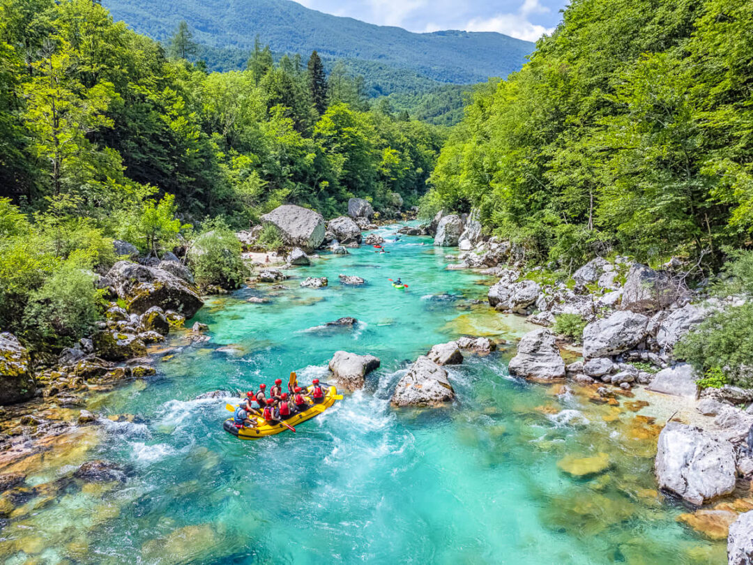 White-water rafting on a turquoise mountain river through forested hills and rocky rapids