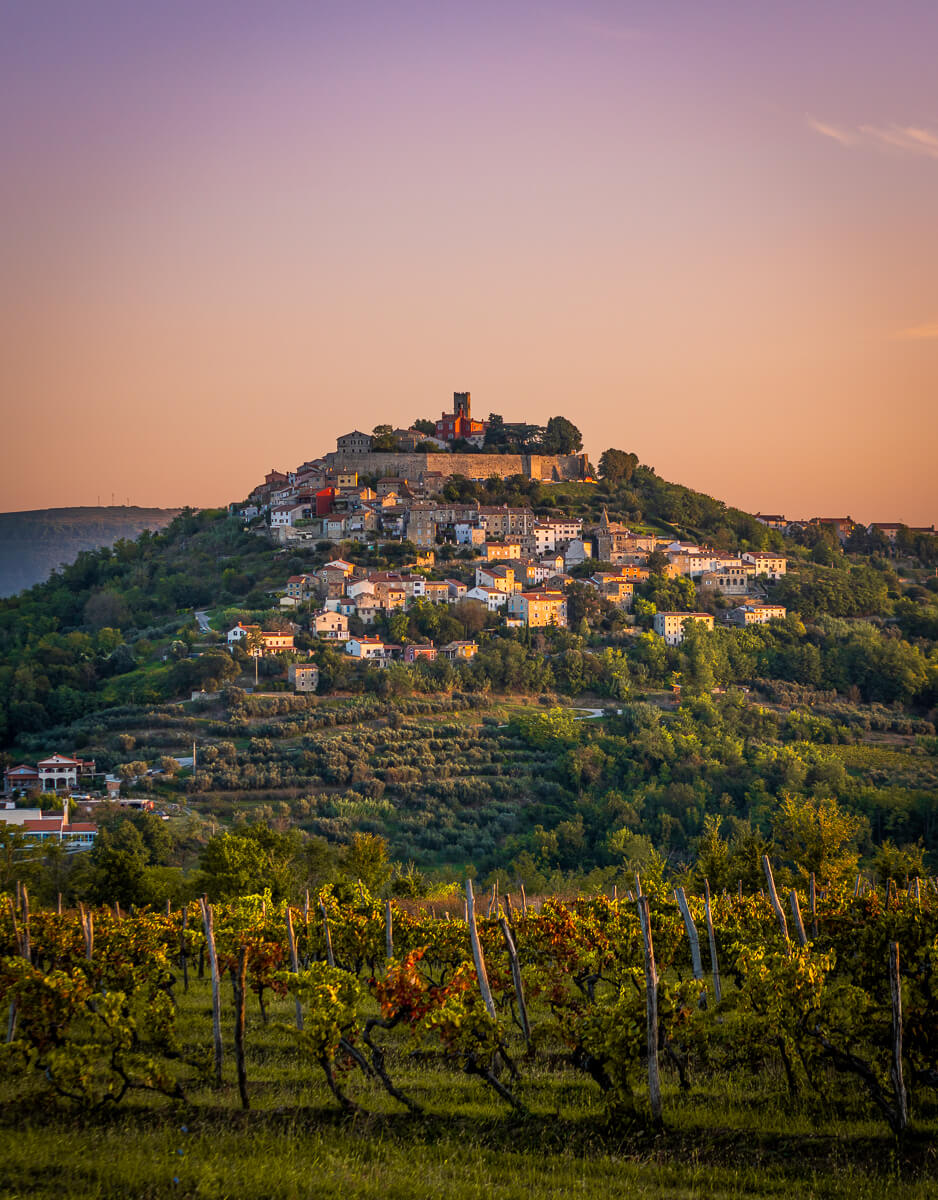 Hilltop village at sunset surrounded by vineyards and olive groves in the countryside