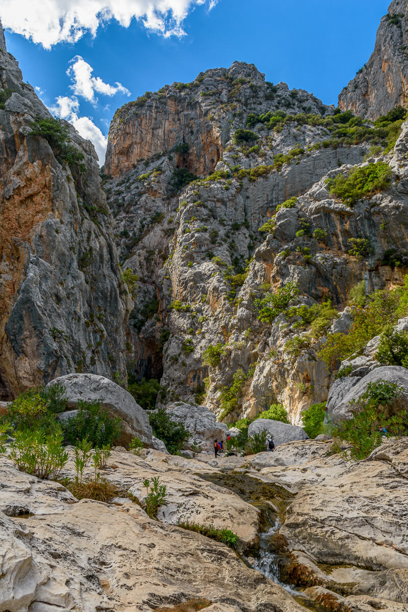 Hikers in a rocky canyon with mountains and cliffs, East Sardinia