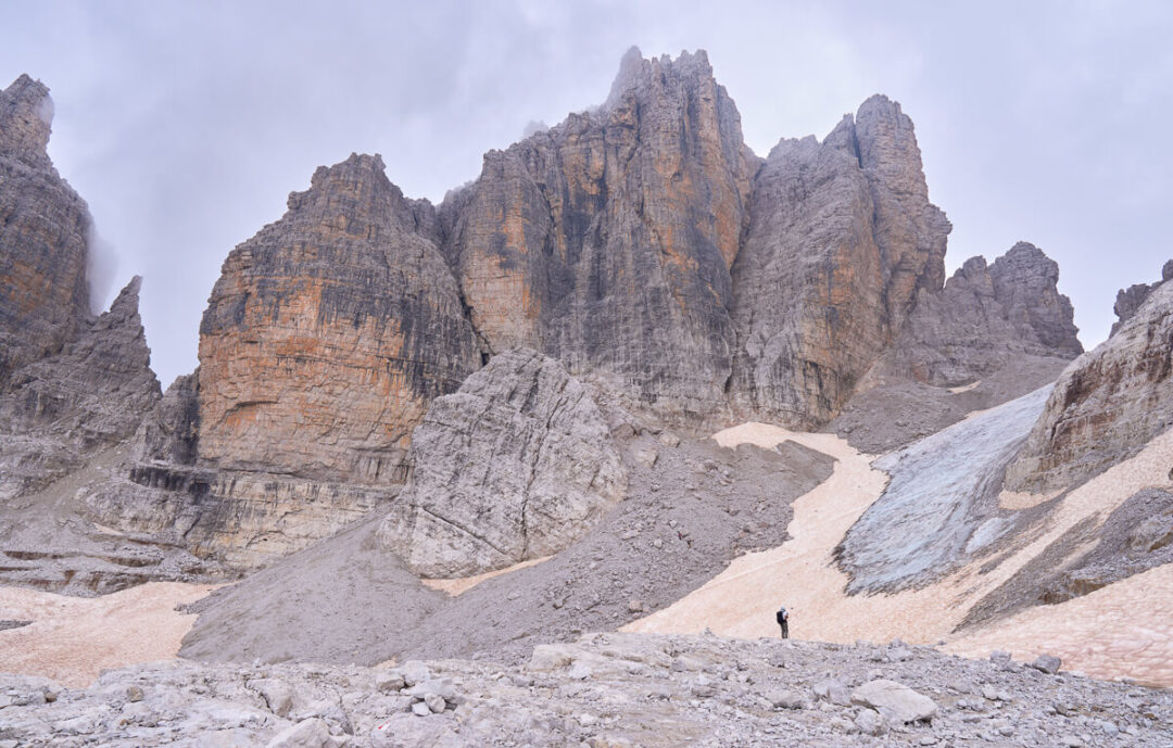 Via ferrata route through dramatic rock towers and valley in the Dolomites, Italy, with hikers on the path
