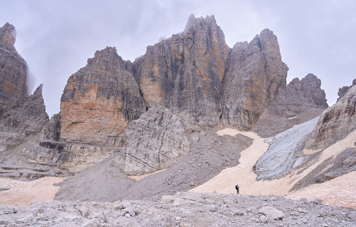 Via ferrata route through dramatic rock towers and valley in the Dolomites, Italy, with hikers on the path