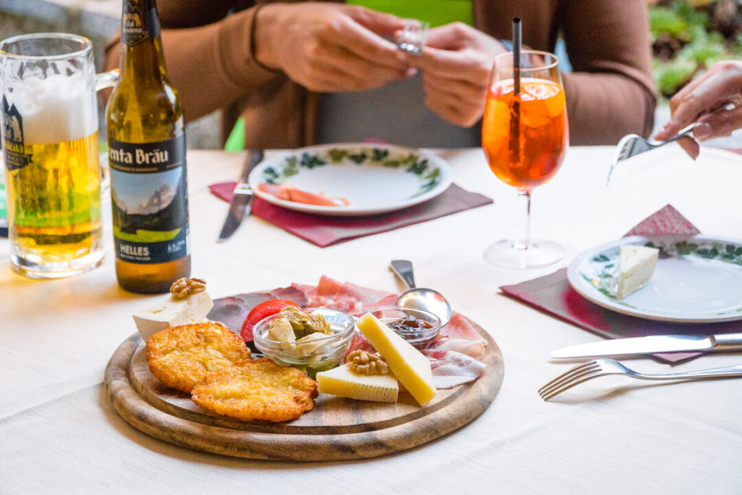 Women toasting over a shared meal at a restaurant table with wine and appetisers
