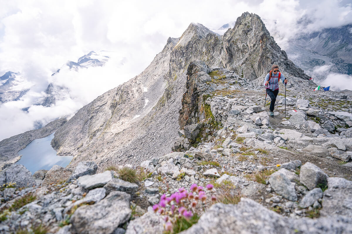 Women’s hiking trip in the Dolomites, Italy, with a woman trekking on a rocky mountain ridge.