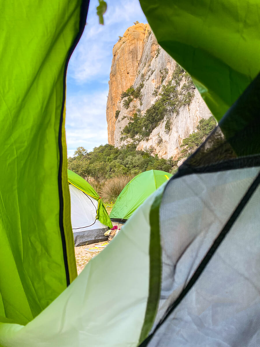 Camping tents overlook rugged cliffs on Sardinia’s east coast during a hiking adventure