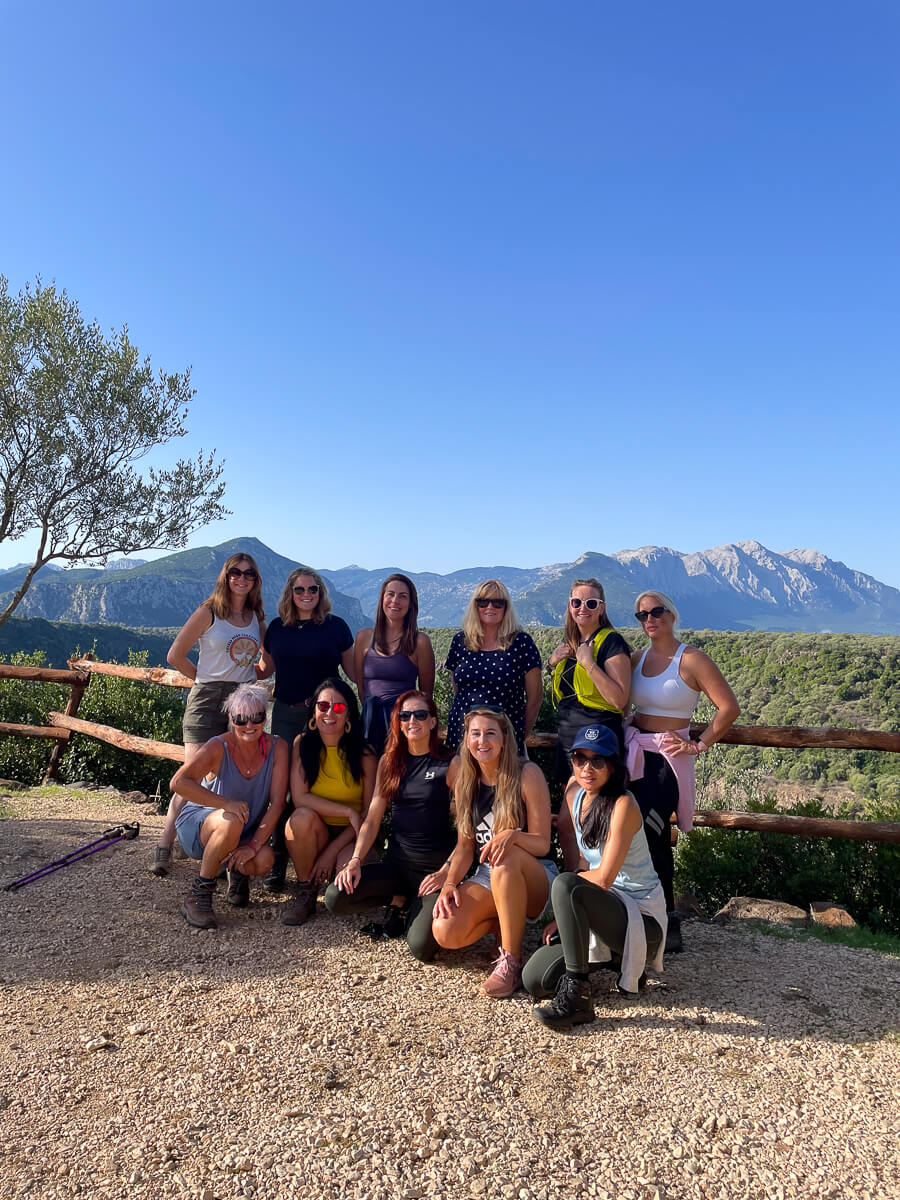 Women on a hiking break overlooking mountains in East Sardinia under a clear blue sky