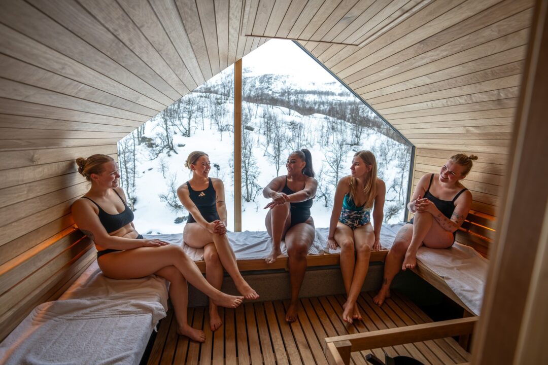 Women relaxing in a wooden sauna.