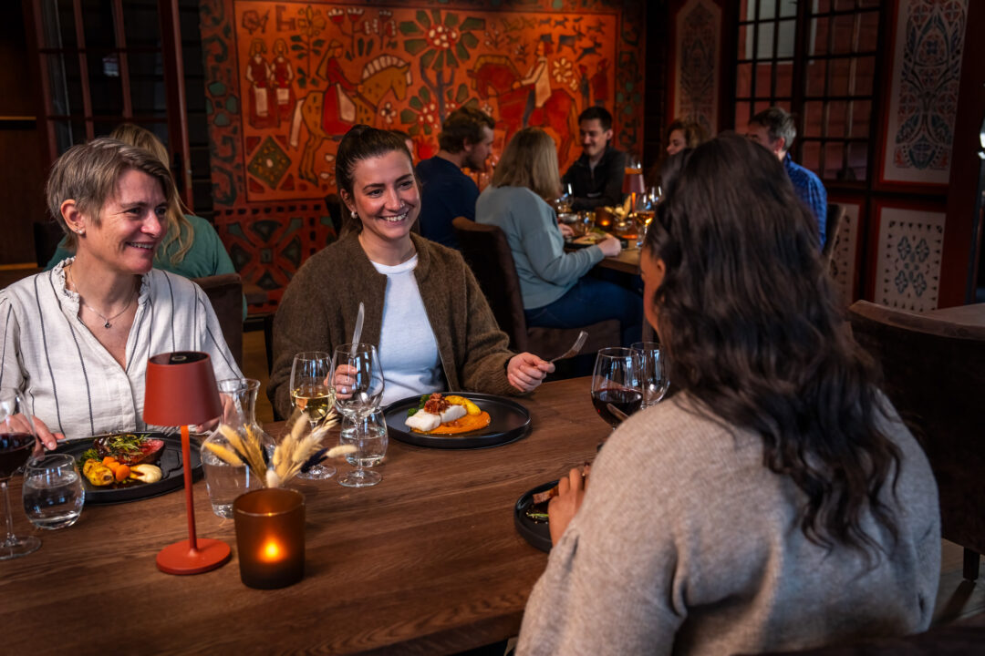 Women dining together at a restaurant table with meals and drinks