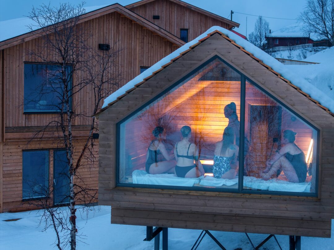 People relaxing in a glass sauna.