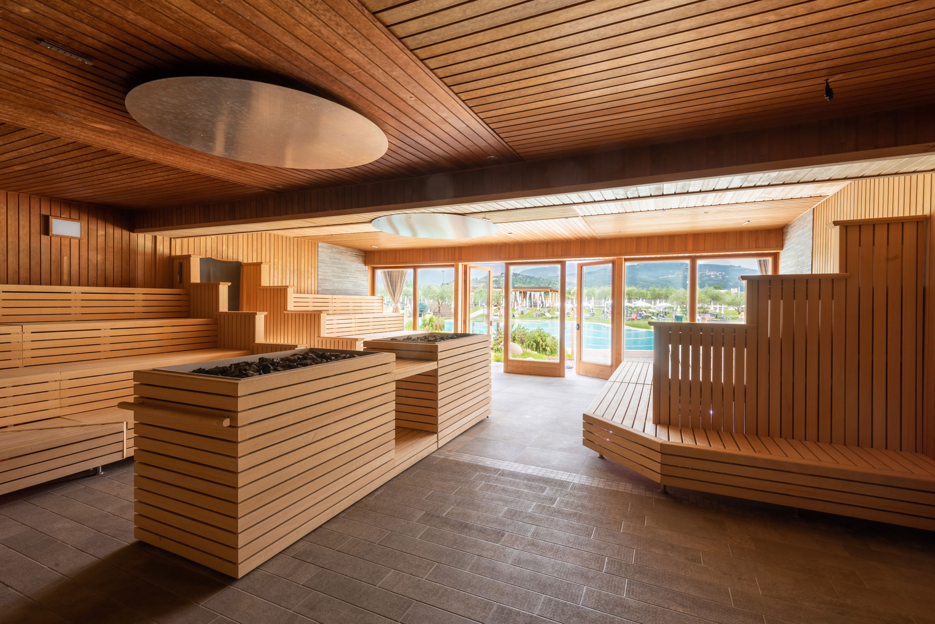 Wooden alpine hut lounge interior with benches and panoramic mountain view through large windows