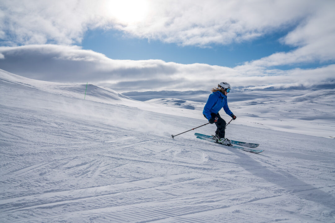 Skier gliding down snowy slope.