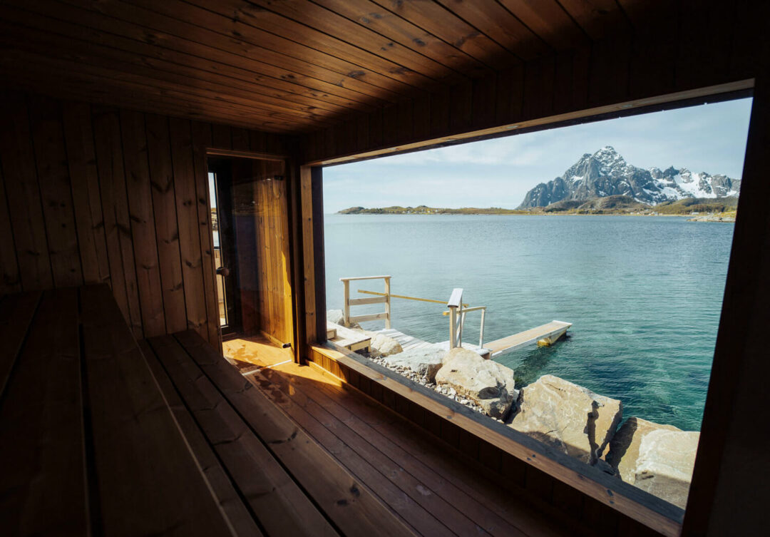 Waterfront view from a wooden cabin, calm sea and Lofoten mountains across the bay
