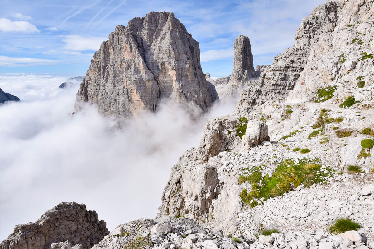 Rocky via ferrata route in the Dolomites, with dramatic limestone peaks above mist and clouds