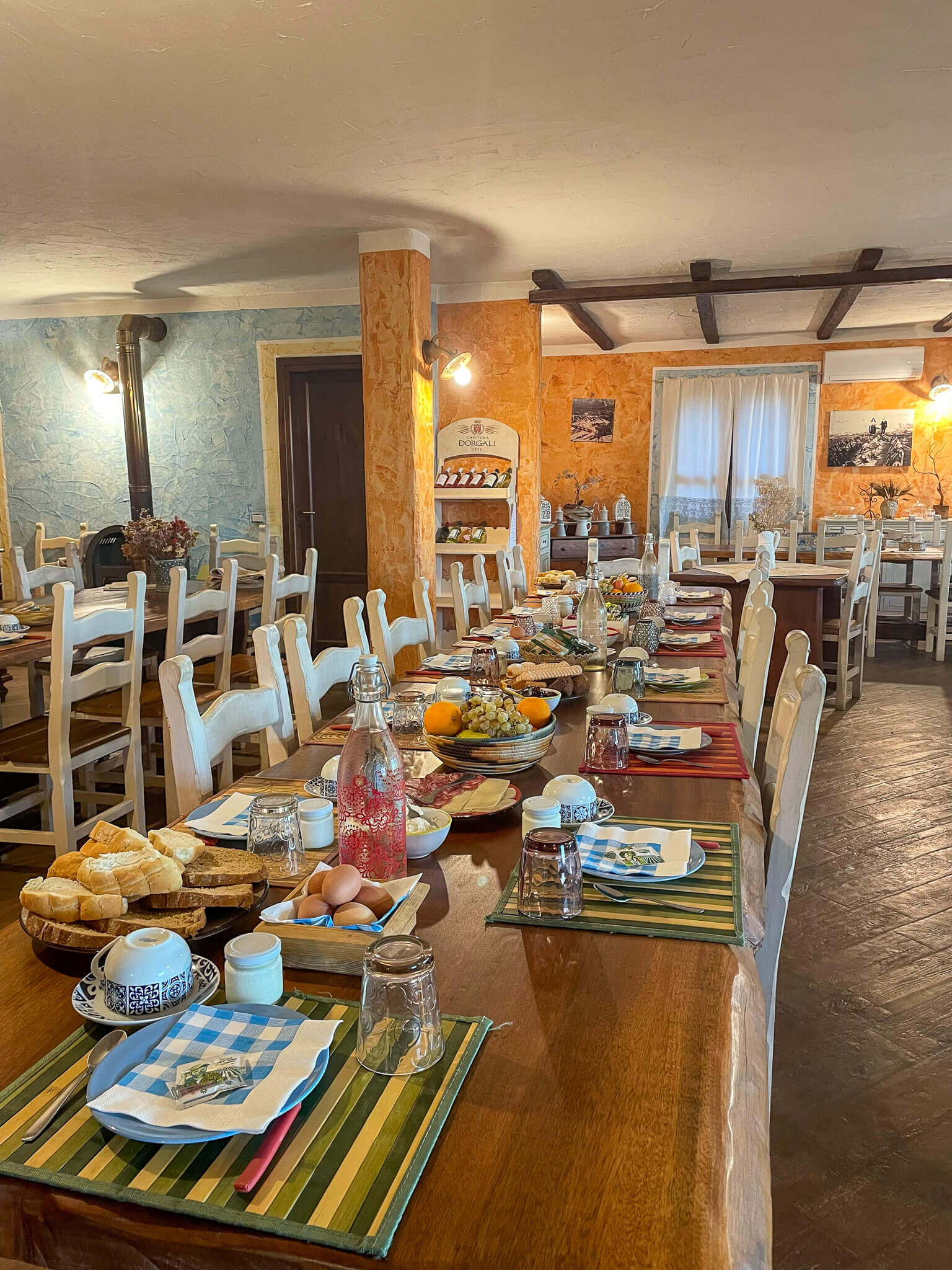 Set dining room breakfast table with pastries, fruit and crockery indoors