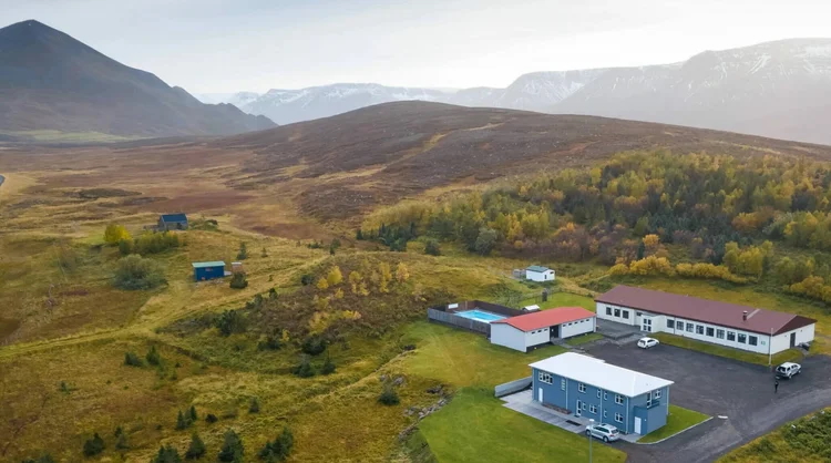 Aerial view of rural Iceland farm buildings in a valley with mountains in the background